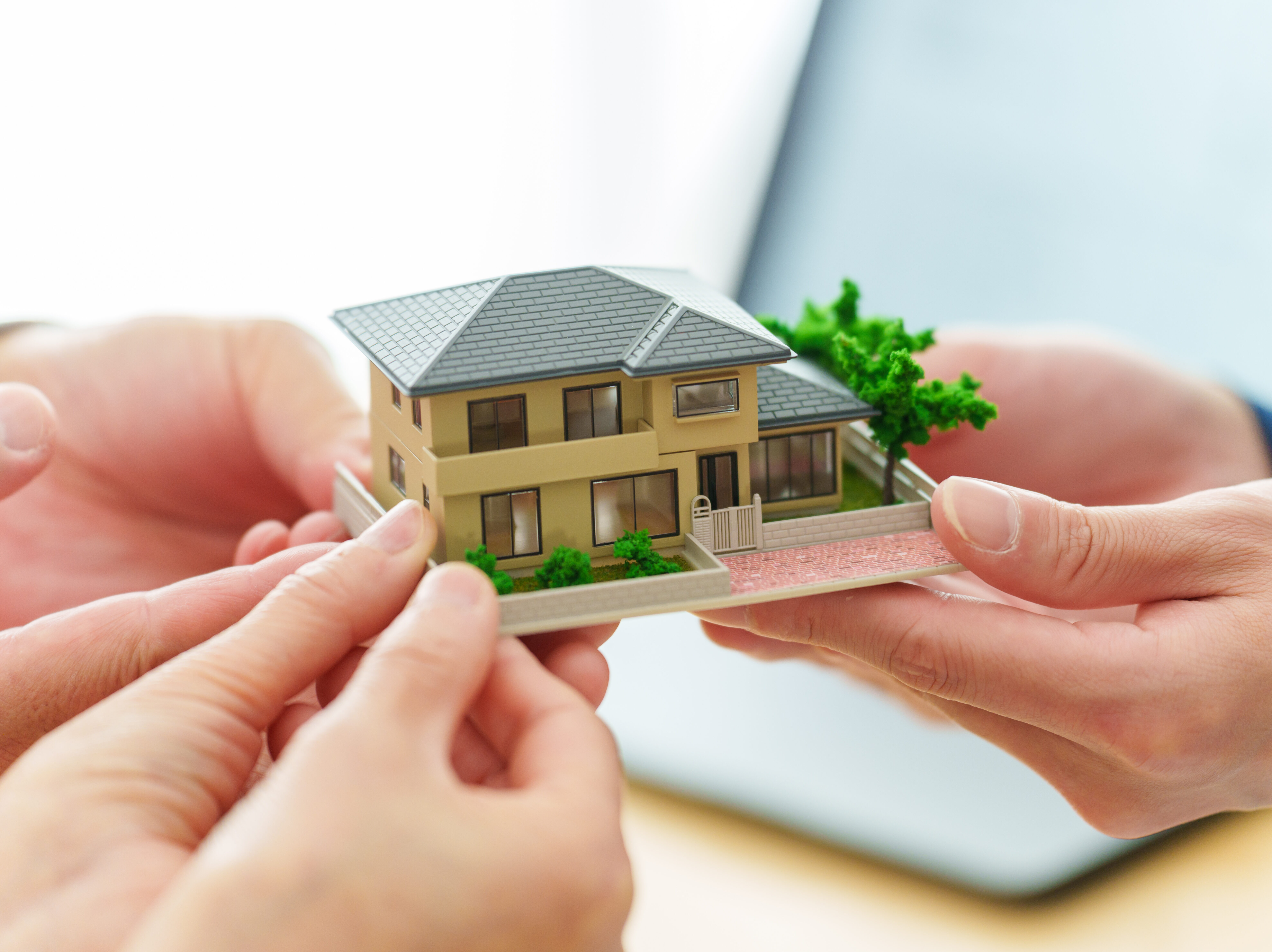 不動産の模型を持つ人の手